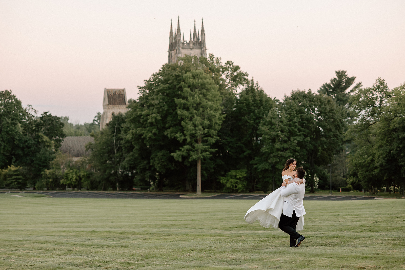 bride carried by groom in gardens